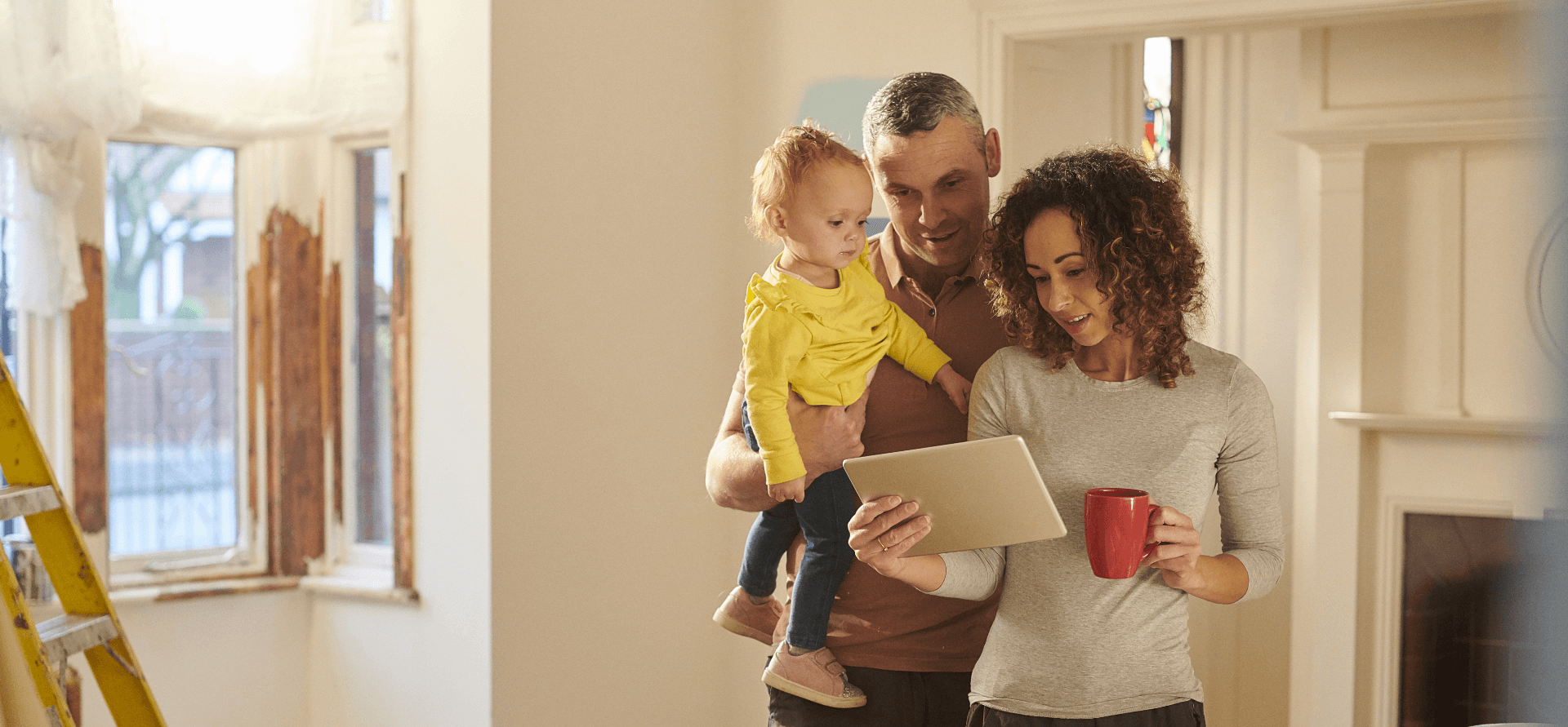 A couple with a child reviewing their home renovation plans.