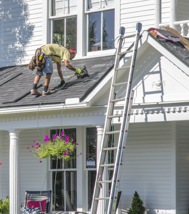 Roofing contractors replacing a damaged roof.