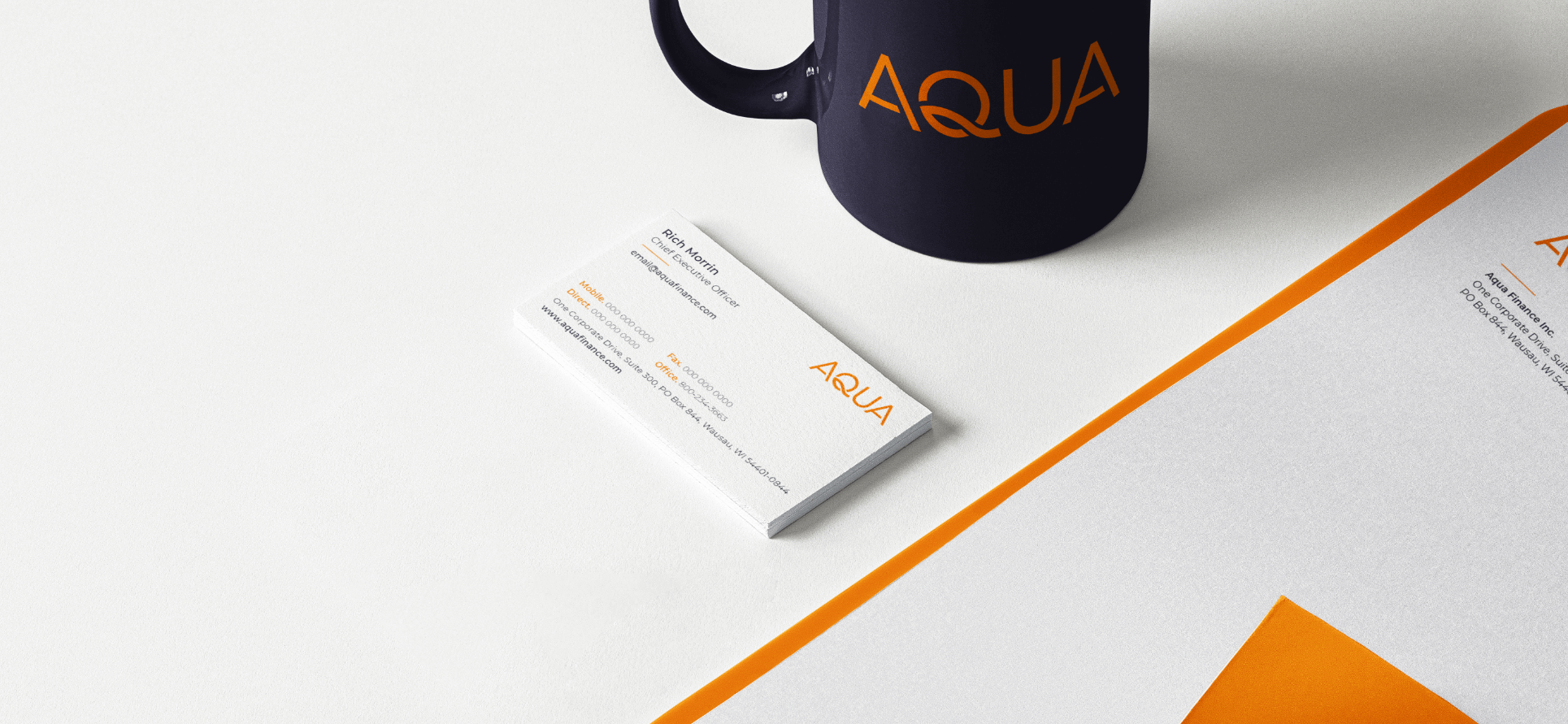 Papelería y taza con la marca Aqua.