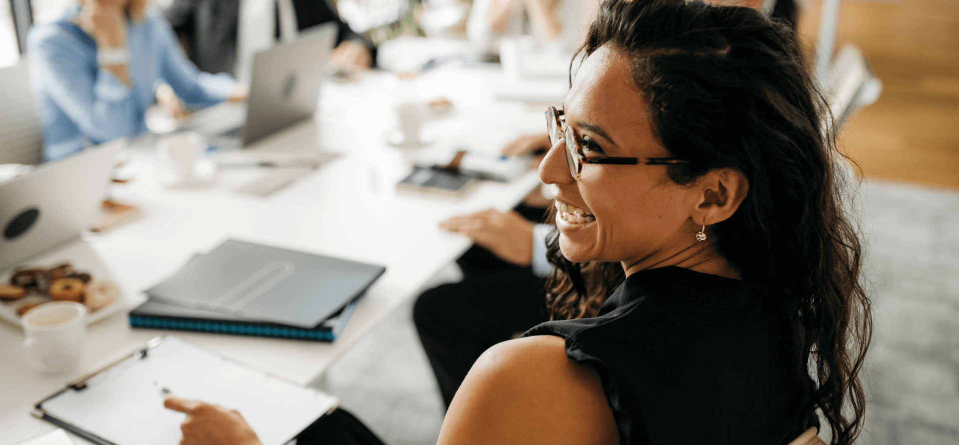 Person at a conference table and laughing with their colleagues.