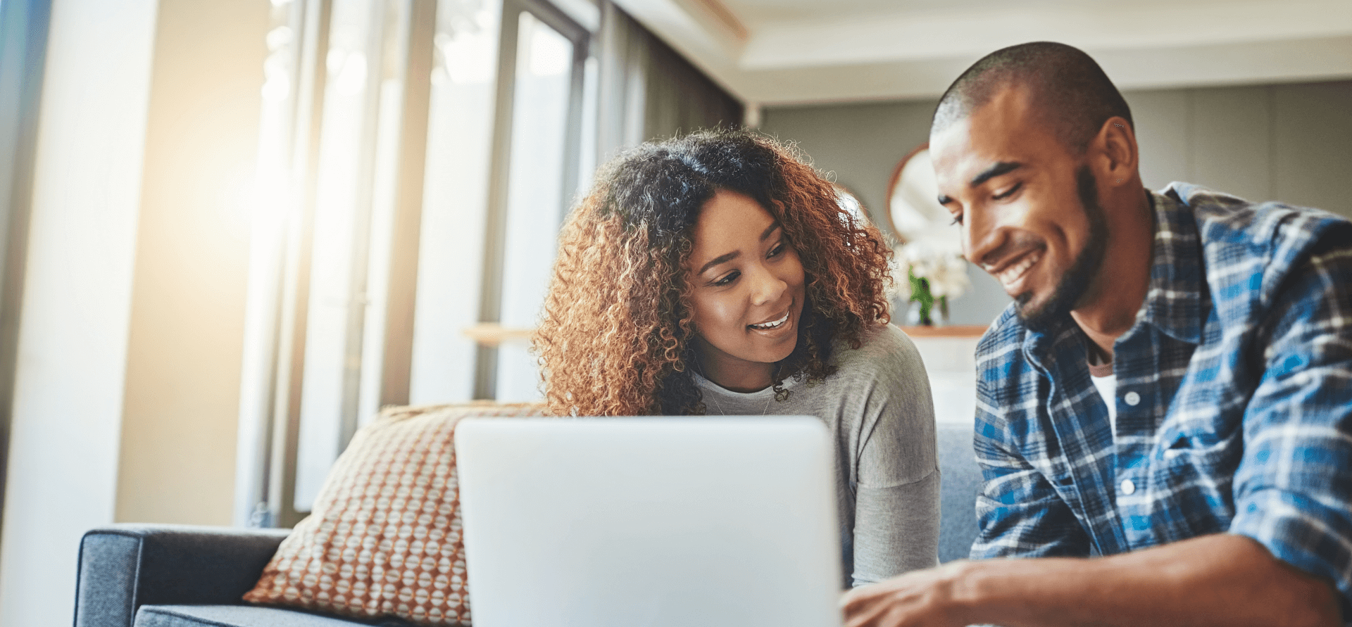 A young couple using a laptop while working on their home finances.