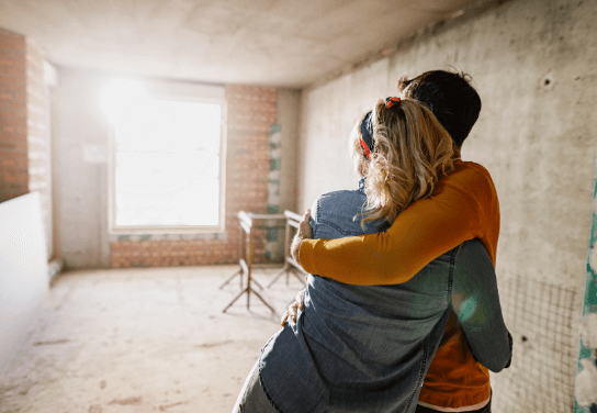 A couple embracing in their apartment under renovation.