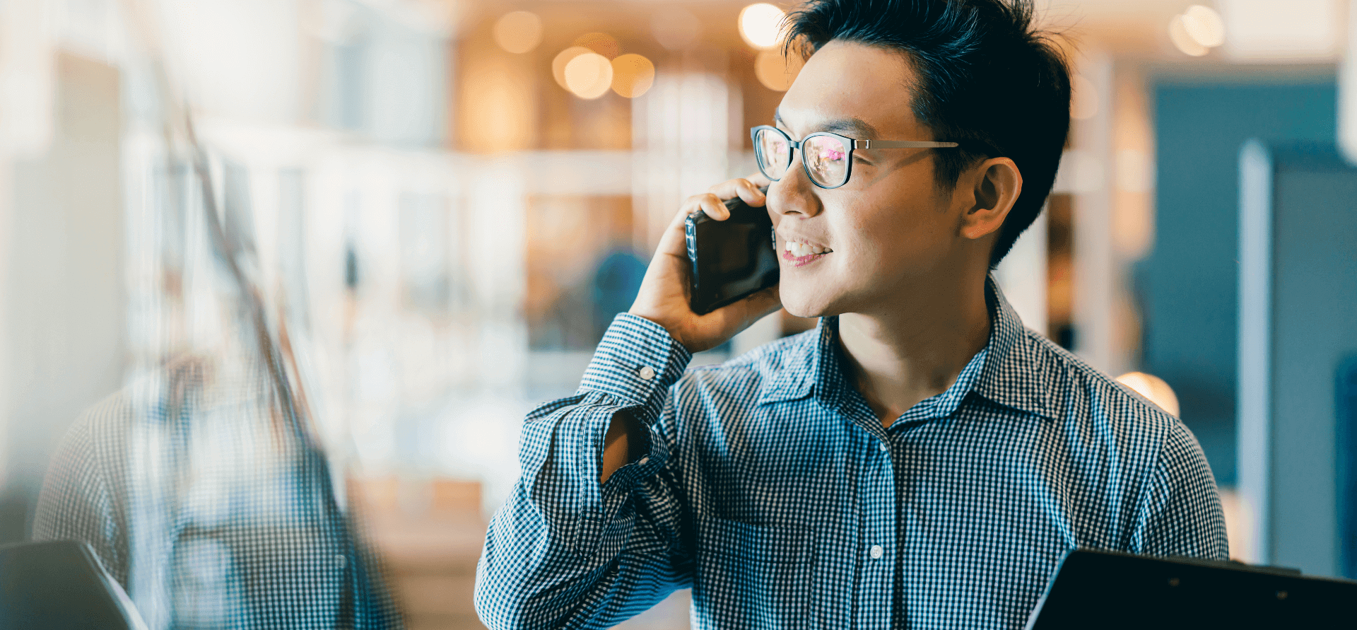 Person smiling while using a smartphone in an office.