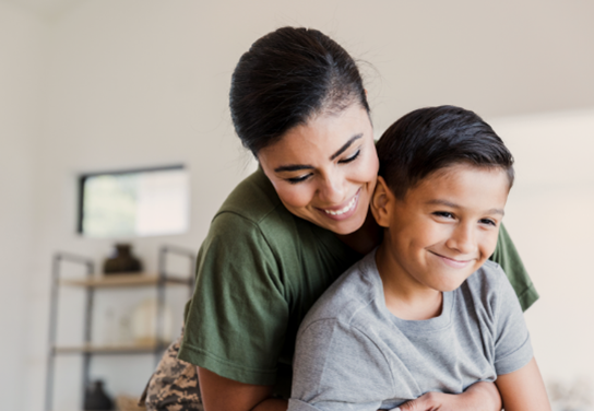 Una madre se sienta detrás de su hijo pequeño y lo abraza.