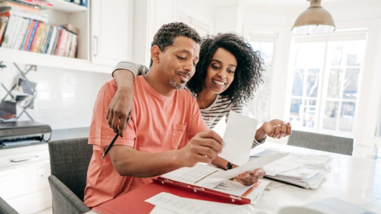 A couple sits together at a kitchen counter.