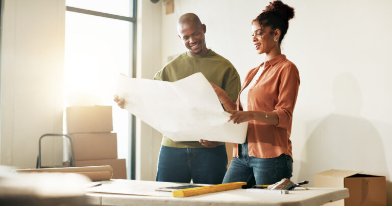 Blueprint, boxes and interior design with couple in new home together for diy project or renovation. Floor plan, smile and talking with homeowner people in apartment for development or improvement.