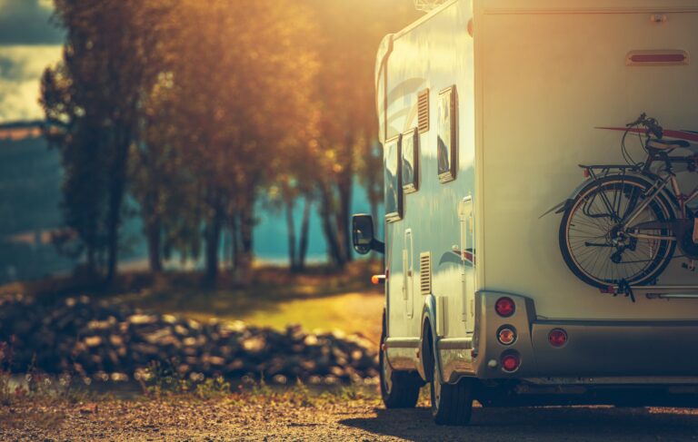 Autumn RV Camping. Modern Camper Van During Late Sunny Fall Afternoon. Scenic RV Park.