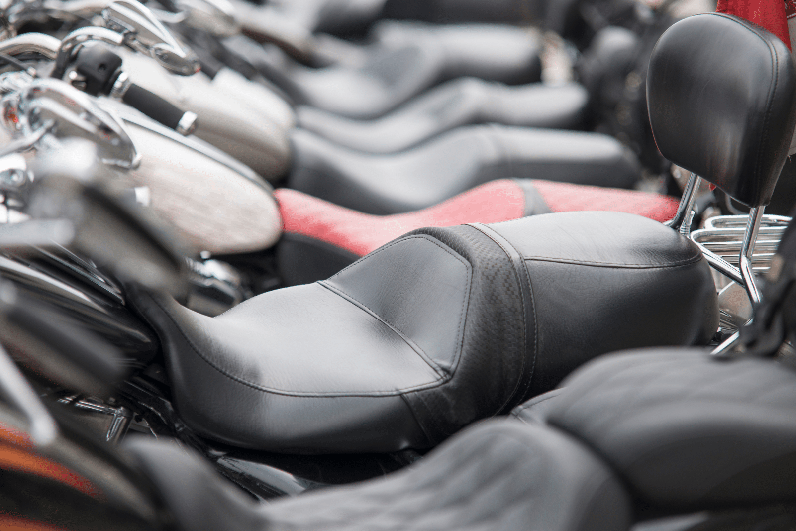 Close up image of a row of motorcyle seats.